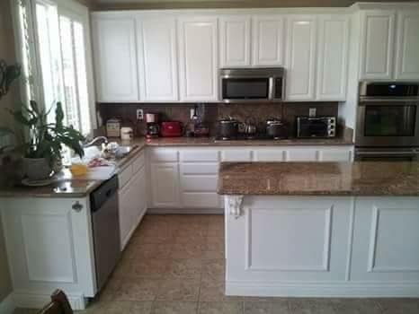picture of a newly remodeled kitchen with new white cabinets and granite countertops with textured tile